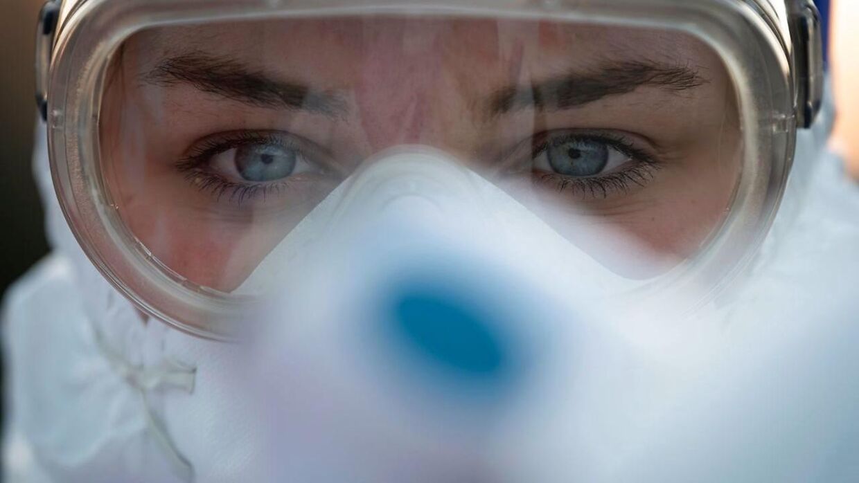 Verdenssundhedsorganisationen, WHO, har 11. marts 2020, erklæret COVID-19-pandemi. Her ses en sundhedsmedarbejder, inden hun skal til at teste en motorcyklists helbred ved grænsen mellem Italien og Slovenien.